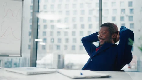 End of working day in office, black man typing, closing cap of laptop, smiling Stock Footage 303748908