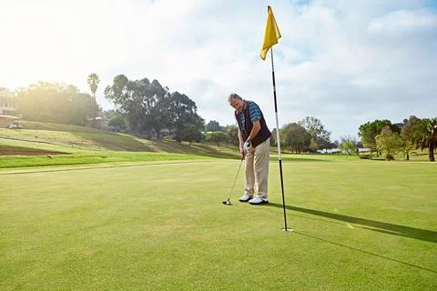 Ending off the front nine. Full length shot of a senior man lining up a put Stock Photos