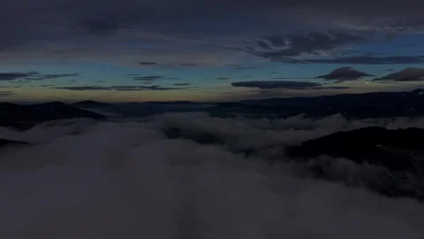 Endless cloud sea beneath dark mountain peaks Stock Footage 328494025