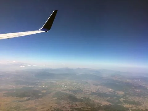 Endless clouds and blue sky under the wing of the plane Stock Photos