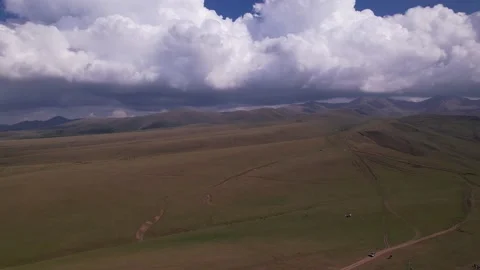 Endless green fields with mountains and big clouds 動画素材 205517940