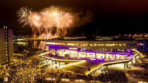 Endless loop crowd watching firework light show above Aarhus city at night Stock Footage