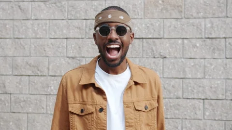 Endless loop of excited Afro-American student nodding head and laughing outdoors Stock Footage 161398011