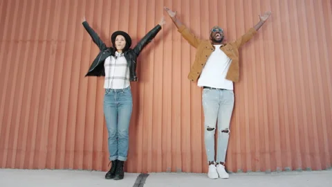 Endless loop of excited mixed race couple dancing outdoors raising arms Stock Footage 161395843