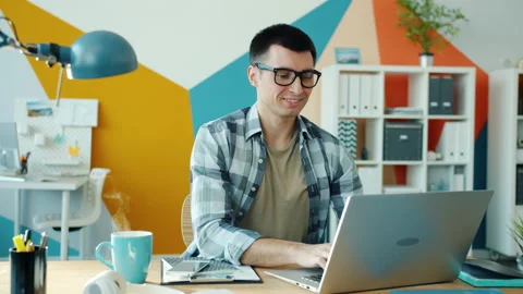 Endless loop of man working with laptop and smiling while steam rising from Stock Footage 132162339