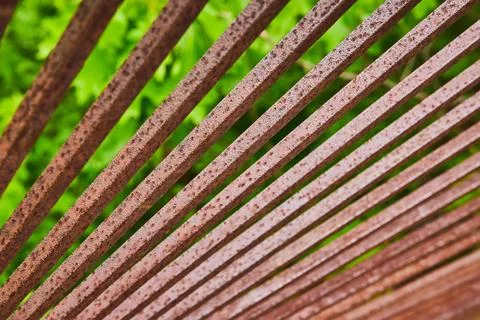 Endless row of rusty red and dark brown metal spokes or bars in macro shot over Stock-Fotos
