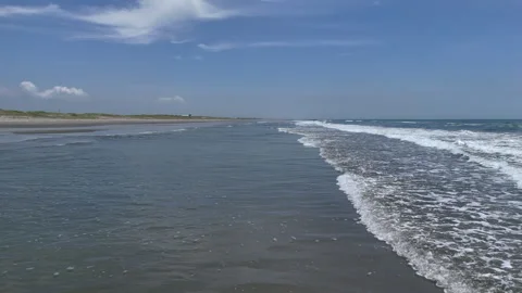 Endless Shoreline with Calm Waves and Blue Sky Stock Footage 286955554