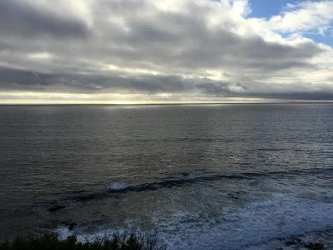 Endless Waves Dance Under a Dramatic Sky at the Coastal Shoreline Stock Photos