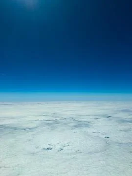 Endless white clouds stretch beneath a bright blue sky during a serene flig.. Stock-Fotos