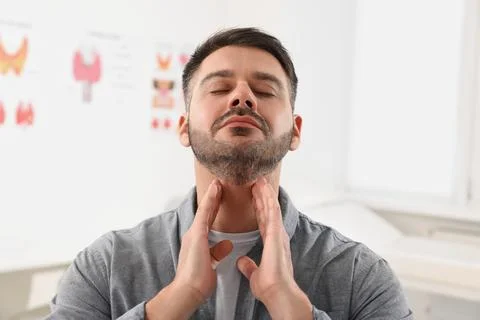 Endocrine system. Man doing thyroid self examination indoors Stockfoto's