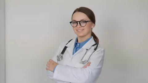 An endocrinologist on a white background smiling in glasses is ready not only to Stock Footage 260564989