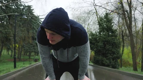 Enduring the Elements A Tired Jogger Finishing His Rainy Day Run Stock Footage 240583557