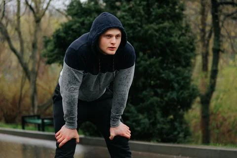 Enduring the Elements A Tired Jogger Finishing His Rainy Day Run Stock Photos