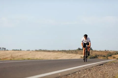 Enduring man practising in cycling during morning time Stock Photos