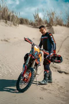 An enduro rider skillfully navigating his motorbike across the desert terrain. Stock Photos