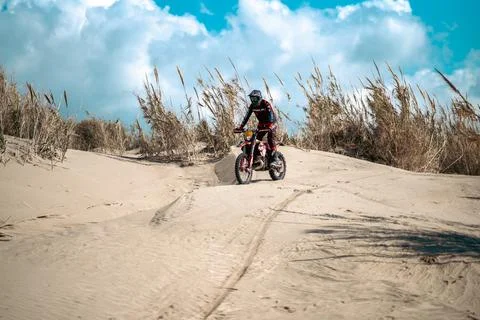 An enduro rider skillfully navigating his motorbike across the desert terrain. Stock Photos