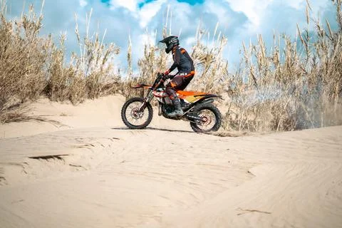 An enduro rider skillfully navigating his motorbike across the desert terrain. Stock Photos