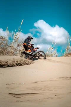 An enduro rider skillfully navigating his motorbike across the desert terrain. Stock Photos