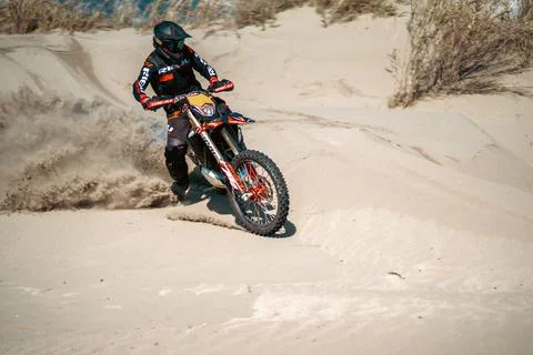 An enduro rider skillfully navigating his motorbike across the desert terrain. Stock Photos