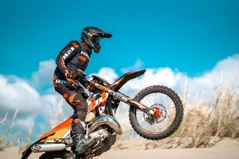 An enduro rider skillfully navigating his motorbike across the desert terrain. Stock Photos