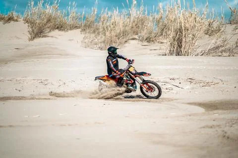 An enduro rider skillfully navigating his motorbike across the desert terrain. Stock Photos