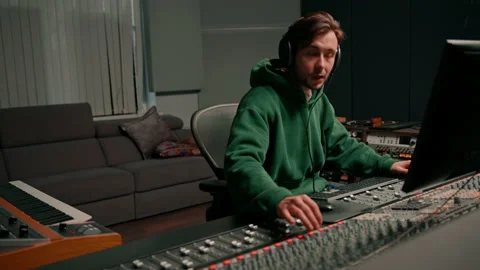 Energetic audio engineer producer working in recording studio mixing tracks on Stock Footage 237968738