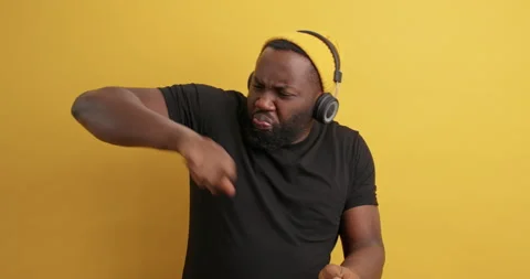 Energetic black man with thick beard shakes hands moces carefree has fun dressed Stock Footage 150297805