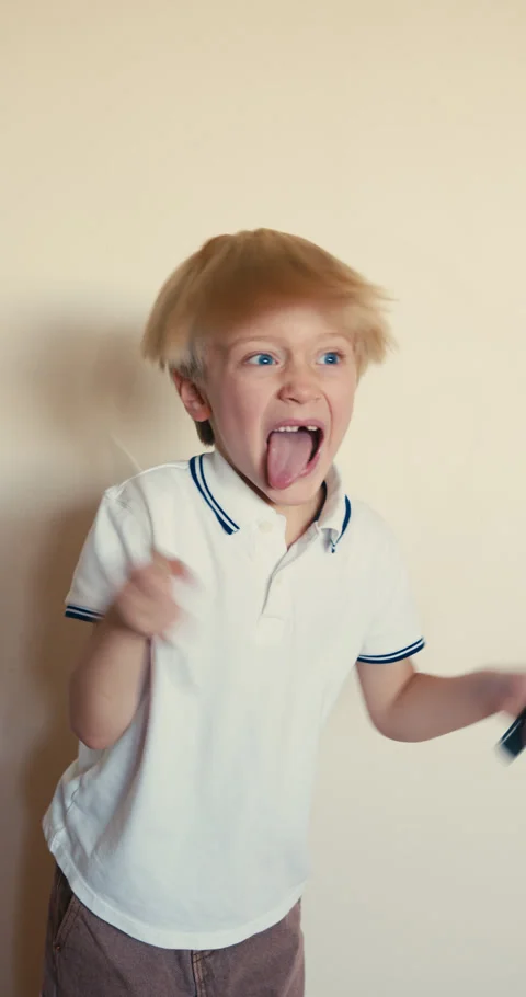 Energetic blond boy making silly faces at camera 動画素材 346983241
