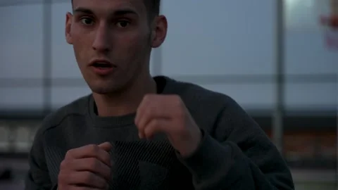 Energetic Boxing Session: Guy Throws Punches on Palm-Fringed Basketball Court Stock Footage 243169395