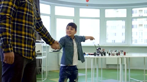 Energetic boy eagerly pulls his father to join in playtime Stock Footage 311920925