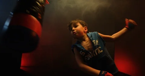 Energetic boy practice his boxing skill on punching bag Stock Footage 112076615