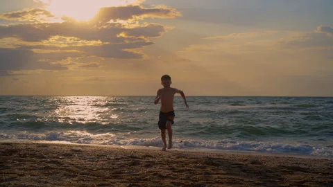 Energetic Boy Running on the Beach at Sunset Stock Footage 312767215