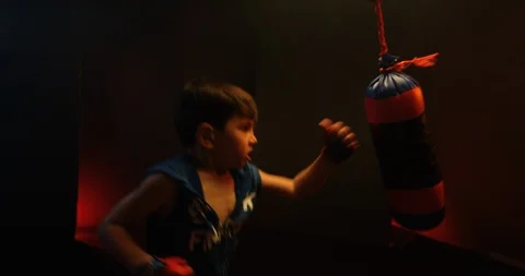 Energetic boy training boxing on punching bag at the gym Stock Footage 112077554