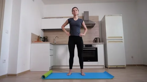 Energetic brunette girl does exercise on the gym mat at home in the kitchen Video stock 149643069