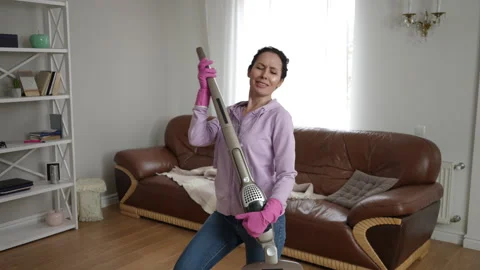 Energetic Cleaning Routine Enhanced with Stylish Vacuuming Dance Moves Stock Footage 309379950