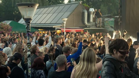 Energetic crowd dances and cheers at an outdoor live concert in Christiania Stock Footage 344982773