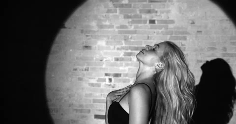 Energetic Dancer Stares at the Camera as She Dances on a Dark Backdrop Stock Footage 158847266