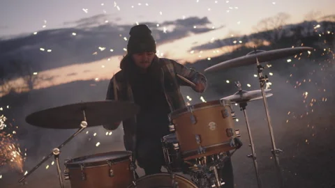 Energetic drummer creates stunning performance with fireworks at sunset Stock Footage 320019304