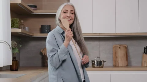 Energetic elderly singer grey-haired old carefree woman lady singing favorite Stock Footage 205223772