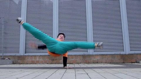 Energetic guy dancer breakdancing outdoors in the city on the street Stock Footage 295068869