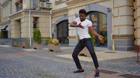 Energetic guy dancing latino dance on street. Man making dance elements in city Stock Footage 144662504