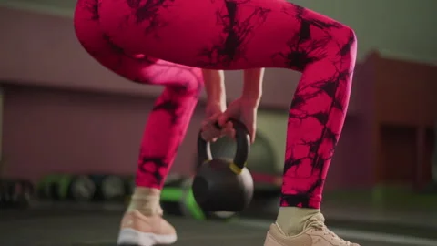 Energetic hip hinge movement, Trainer performs fluid kettlebell swing with power Stock Footage 346375869