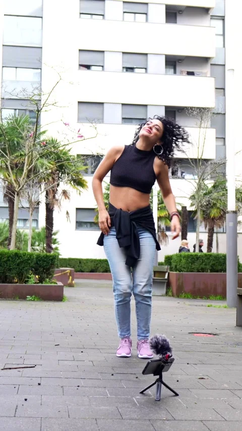 Energetic influencer dancing outdoors, creating content Stock Footage 303060648