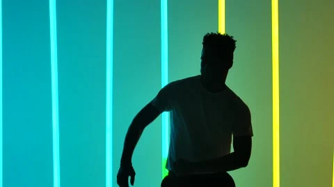 An energetic man is dancing salsa in slow motion. Silhouette of a dancing man in 動画素材 146099405