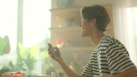 Energetic moving around shot of young man holding yellow smartphone in hands and Stock Footage 302585207