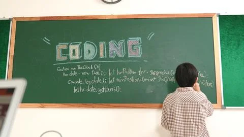 Energetic student standing blackboard while writing coding program. Pedagogy. Stock Photos