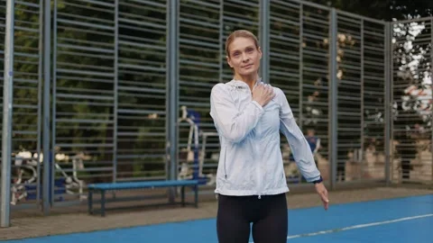 Energetic trainer putting hand on shoulder and spinning arm in circle on court Stock Footage 252193249