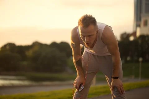 Energetic young man do exercises and runnig with telephone and m Stock Photos