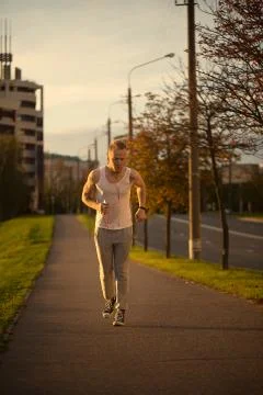 Energetic young man do exercises outdoors in park to keep their Stock Photos