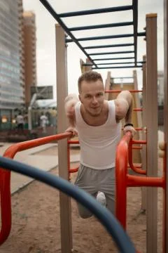 Energetic young man do exercises outdoors in sport square to kee Stock Photos
